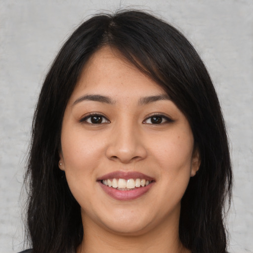 Joyful latino young-adult female with long  brown hair and brown eyes