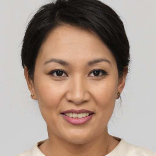 Joyful asian adult female with short  brown hair and brown eyes