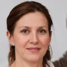 Joyful white adult female with medium  brown hair and grey eyes