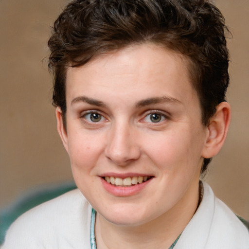 Joyful white young-adult female with short  brown hair and green eyes