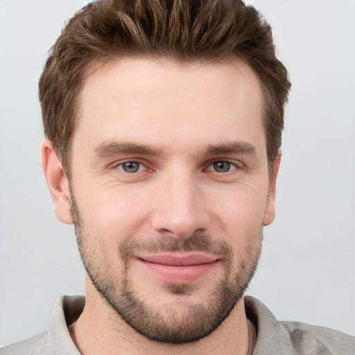 Joyful white young-adult male with short  brown hair and grey eyes