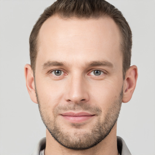 Joyful white young-adult male with short  brown hair and grey eyes