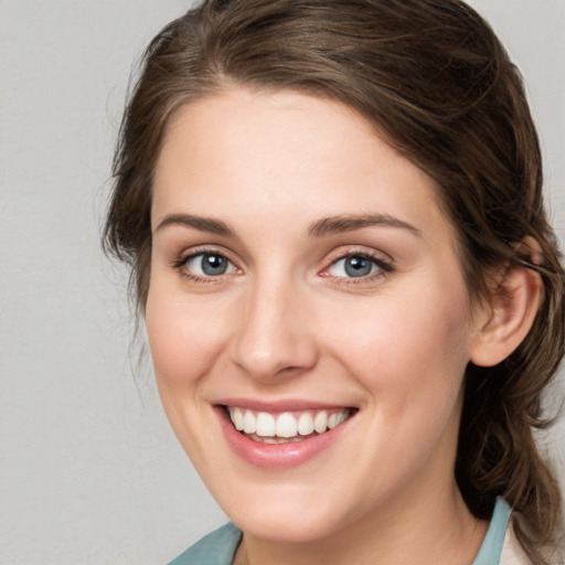 Joyful white young-adult female with medium  brown hair and blue eyes