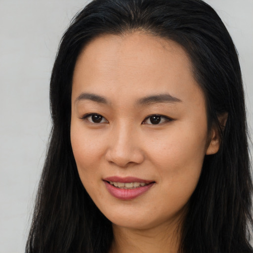 Joyful asian young-adult female with long  brown hair and brown eyes