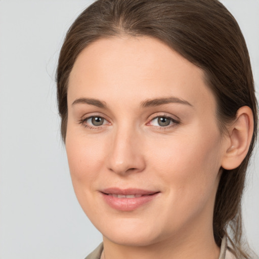 Joyful white young-adult female with medium  brown hair and grey eyes