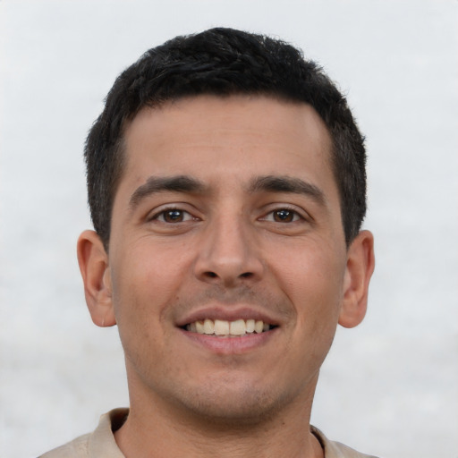 Joyful latino young-adult male with short  brown hair and brown eyes