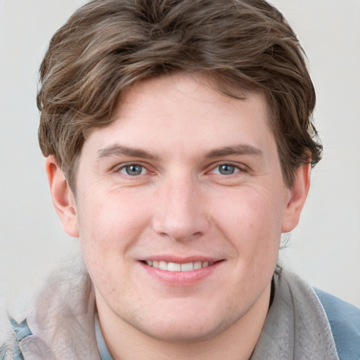 Joyful white young-adult male with short  brown hair and blue eyes