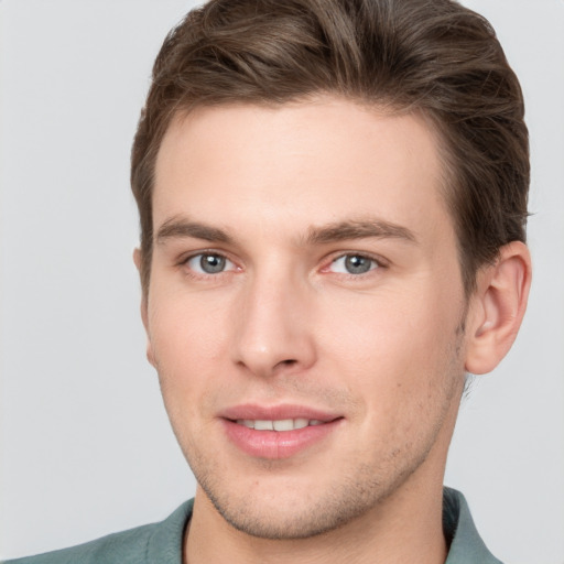 Joyful white young-adult male with short  brown hair and grey eyes