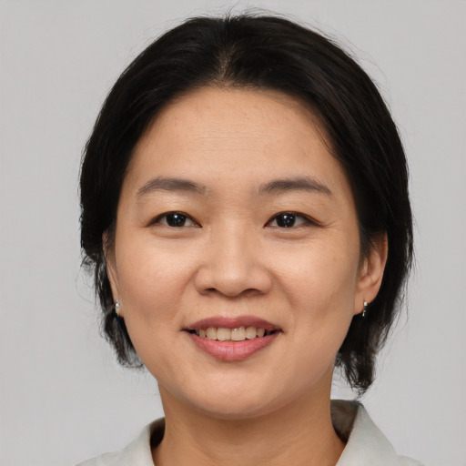 Joyful asian adult female with medium  brown hair and brown eyes
