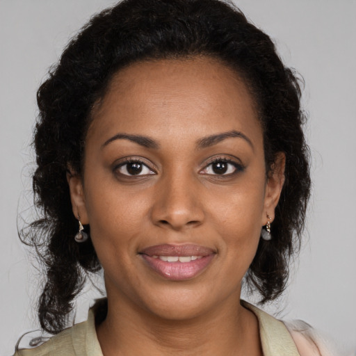 Joyful black young-adult female with long  brown hair and brown eyes