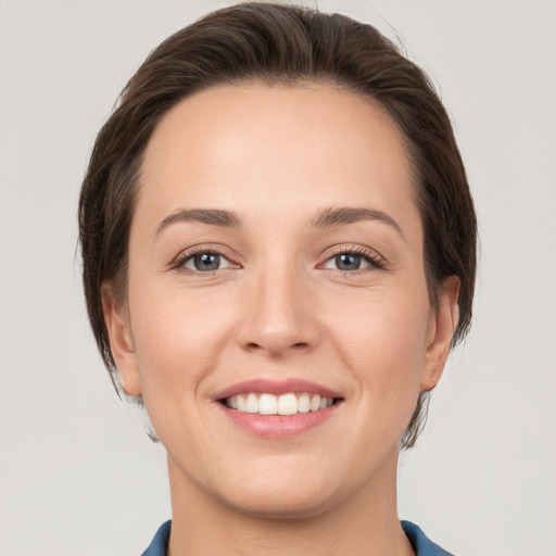 Joyful white young-adult female with medium  brown hair and grey eyes