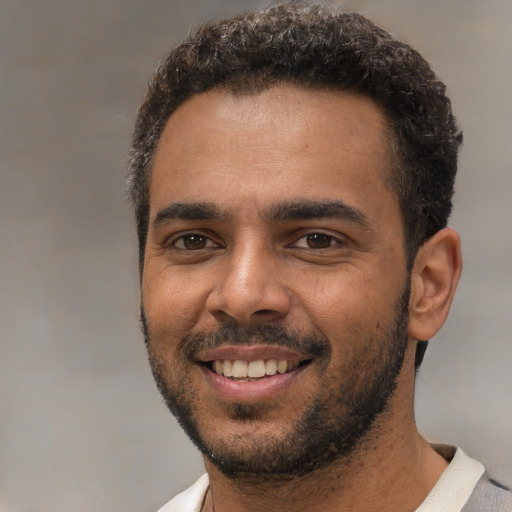 Joyful black young-adult male with short  black hair and brown eyes