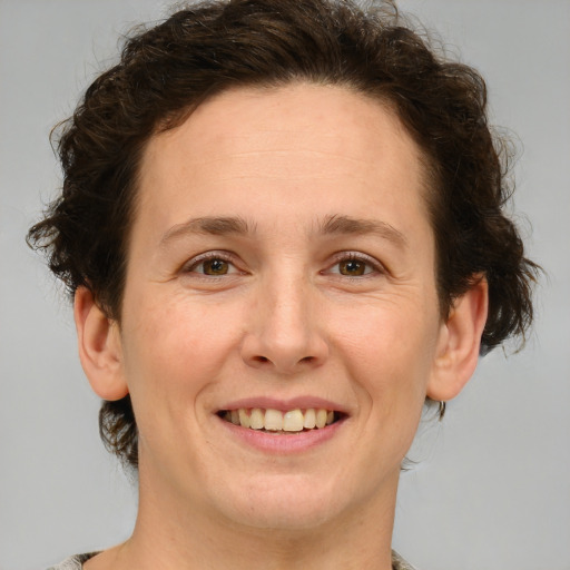 Joyful white adult female with medium  brown hair and green eyes