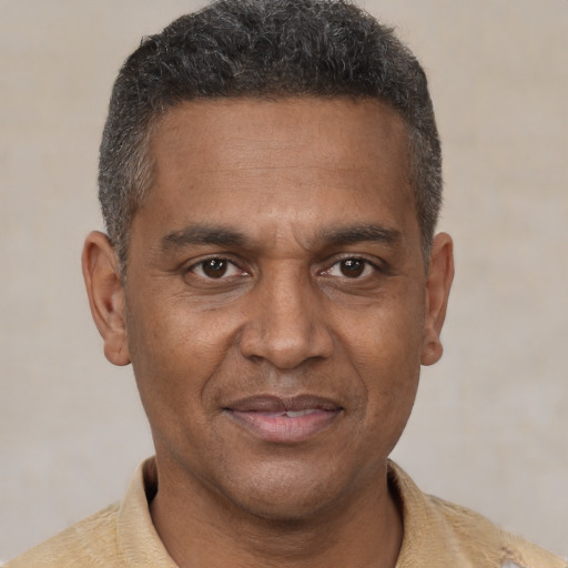 Joyful black adult male with short  brown hair and brown eyes