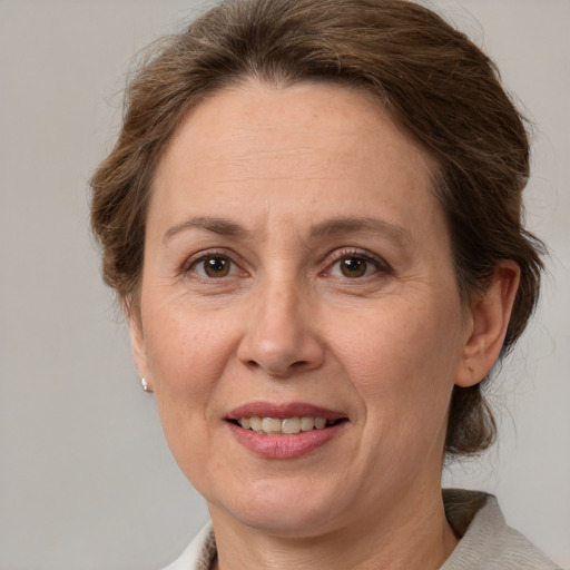 Joyful white adult female with medium  brown hair and grey eyes