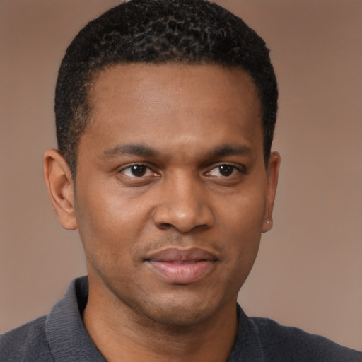 Joyful black young-adult male with short  black hair and brown eyes