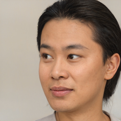Joyful asian young-adult male with short  black hair and brown eyes