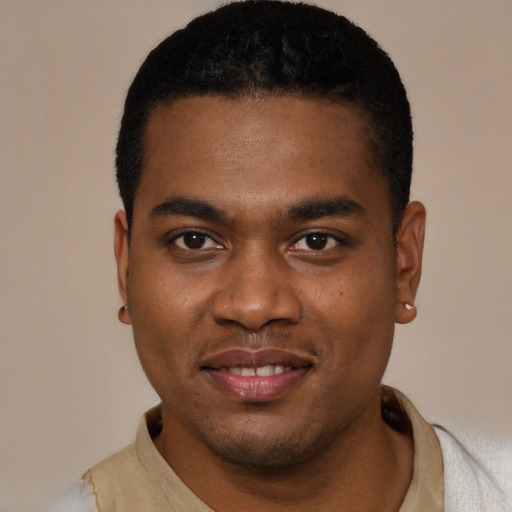 Joyful black young-adult male with short  black hair and brown eyes