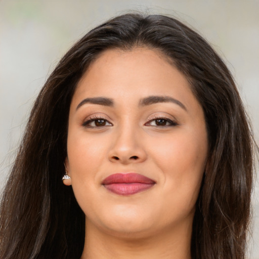 Joyful latino young-adult female with long  brown hair and brown eyes