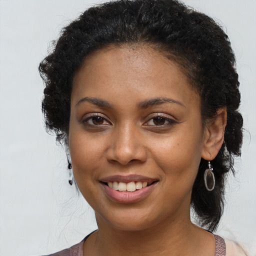 Joyful black young-adult female with long  brown hair and brown eyes