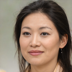 Joyful asian adult female with long  brown hair and brown eyes