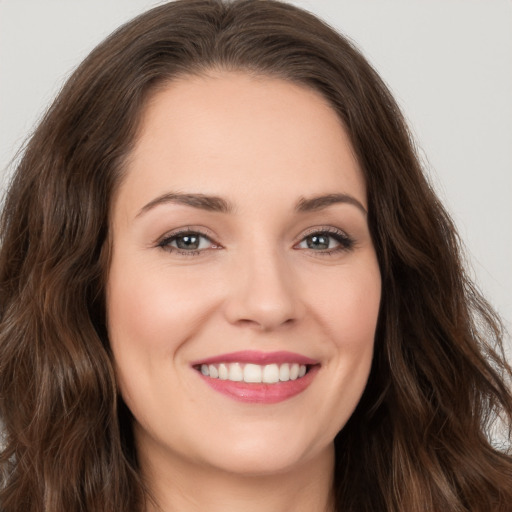 Joyful white young-adult female with long  brown hair and brown eyes