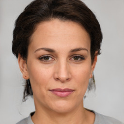 Joyful white adult female with medium  brown hair and grey eyes