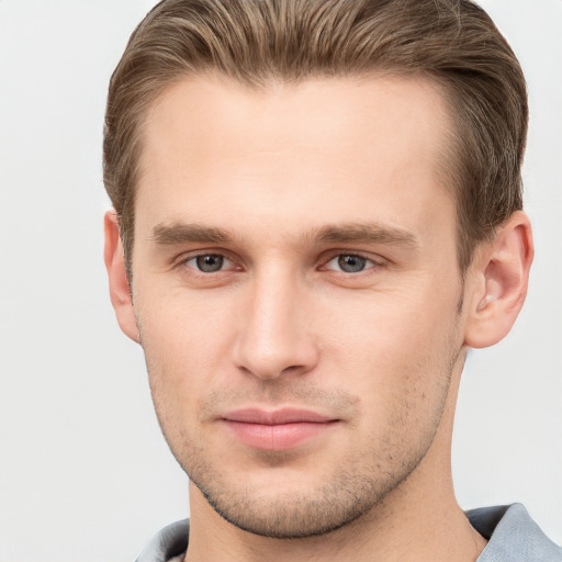 Joyful white young-adult male with short  brown hair and grey eyes