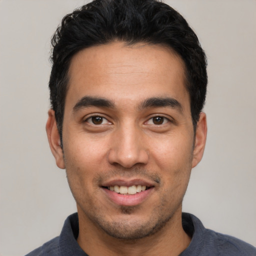 Joyful white young-adult male with short  black hair and brown eyes