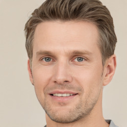 Joyful white young-adult male with short  brown hair and grey eyes