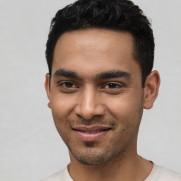 Joyful latino young-adult male with short  black hair and brown eyes