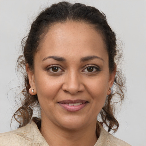 Joyful latino adult female with medium  brown hair and brown eyes