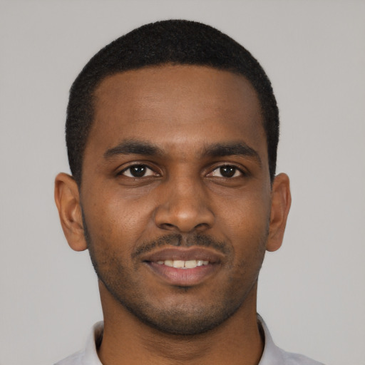 Joyful black young-adult male with short  black hair and brown eyes
