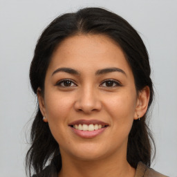 Joyful latino young-adult female with long  brown hair and brown eyes