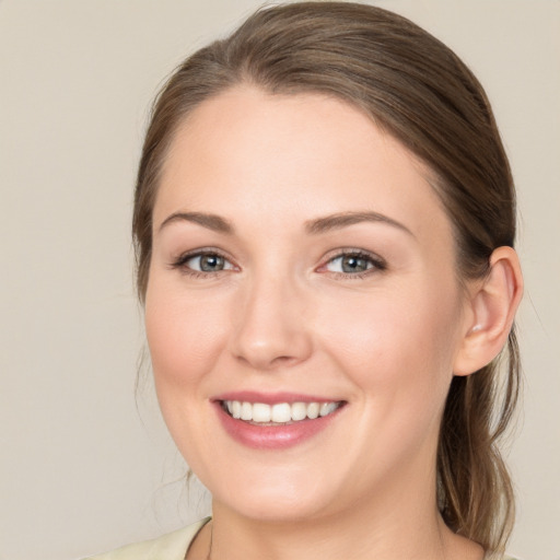 Joyful white young-adult female with medium  brown hair and grey eyes