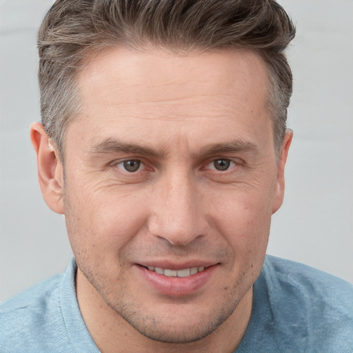 Joyful white adult male with short  brown hair and brown eyes