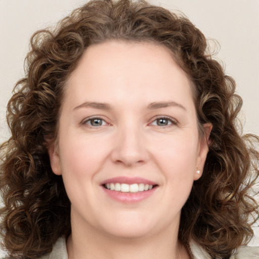 Joyful white young-adult female with medium  brown hair and green eyes