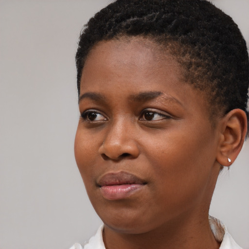Joyful black young-adult female with short  brown hair and brown eyes