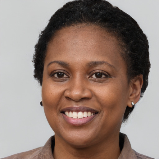Joyful black young-adult female with short  brown hair and brown eyes