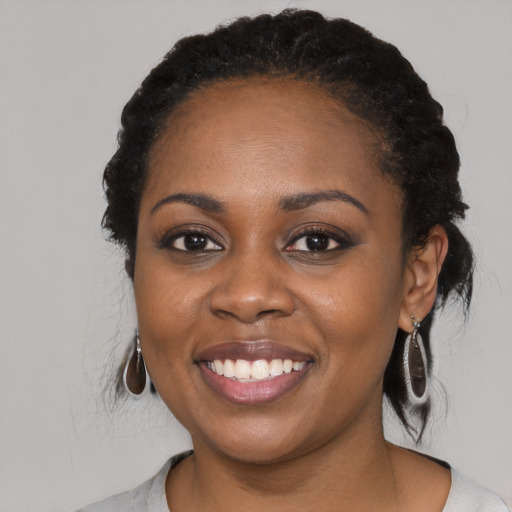 Joyful black young-adult female with medium  black hair and brown eyes