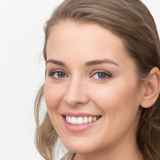 Joyful white young-adult female with long  brown hair and grey eyes