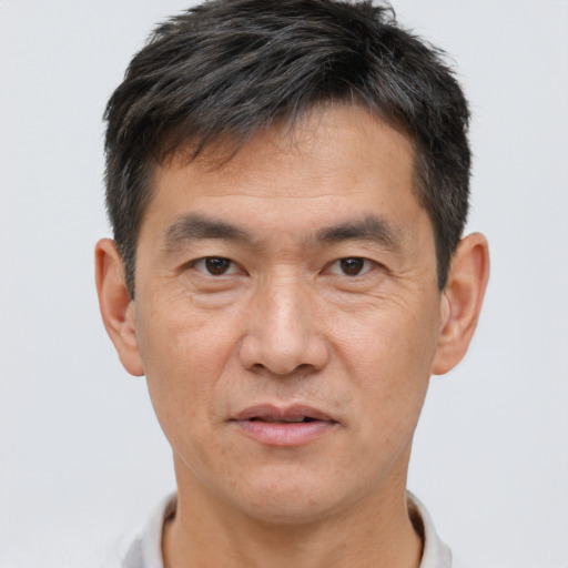 Joyful asian adult male with short  brown hair and brown eyes