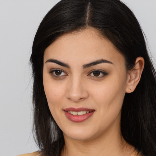 Joyful latino young-adult female with long  brown hair and brown eyes