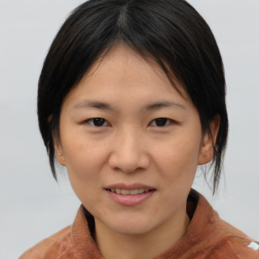 Joyful asian young-adult female with medium  brown hair and brown eyes