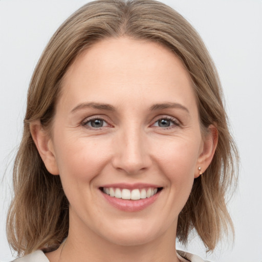 Joyful white young-adult female with medium  brown hair and grey eyes