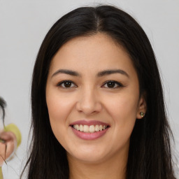 Joyful latino young-adult female with long  brown hair and brown eyes