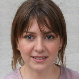 Joyful white young-adult female with medium  brown hair and blue eyes