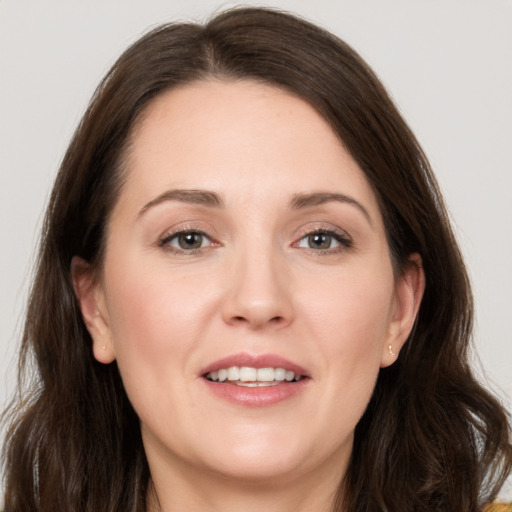 Joyful white young-adult female with long  brown hair and brown eyes