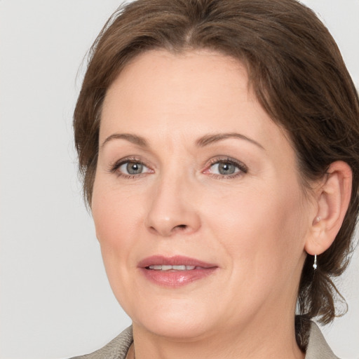 Joyful white adult female with medium  brown hair and grey eyes