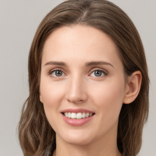 Joyful white young-adult female with long  brown hair and green eyes